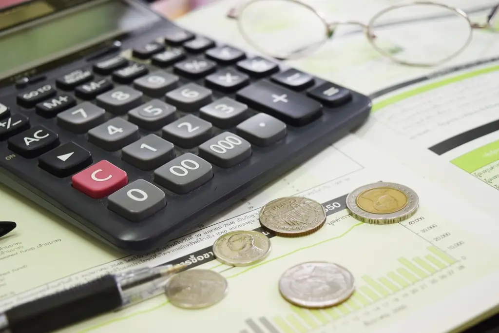Coins and calculator representing design pricing and budget planning