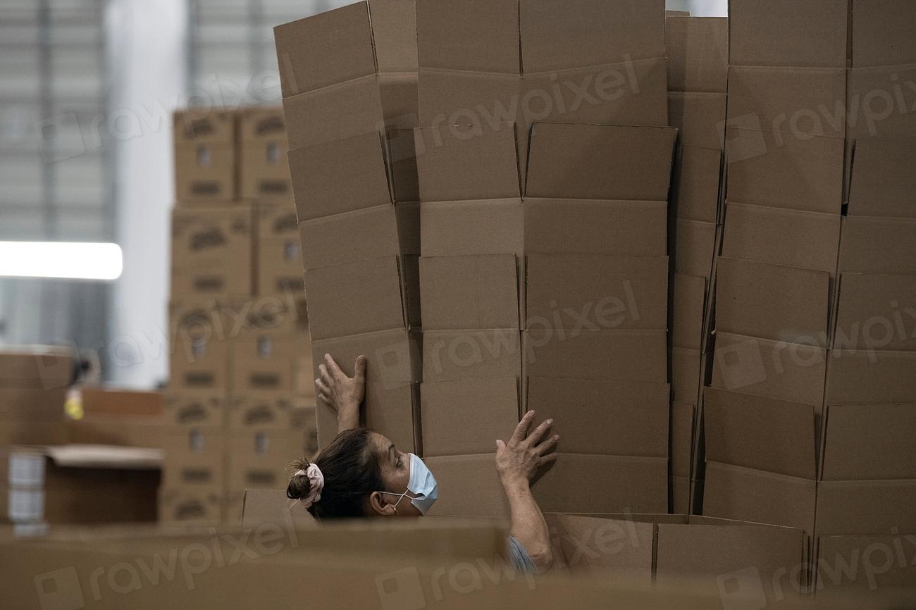 Warehouse worker organizing stacked inventory boxes