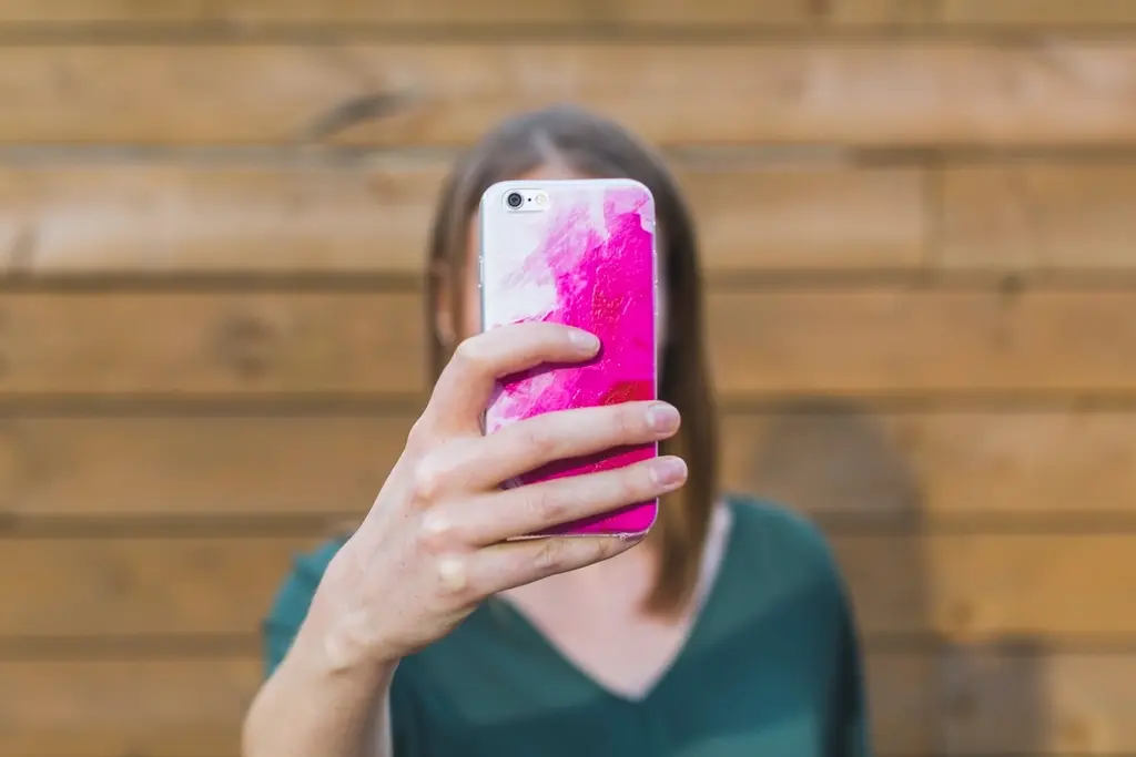 Woman holding a smartphone showing a social media app