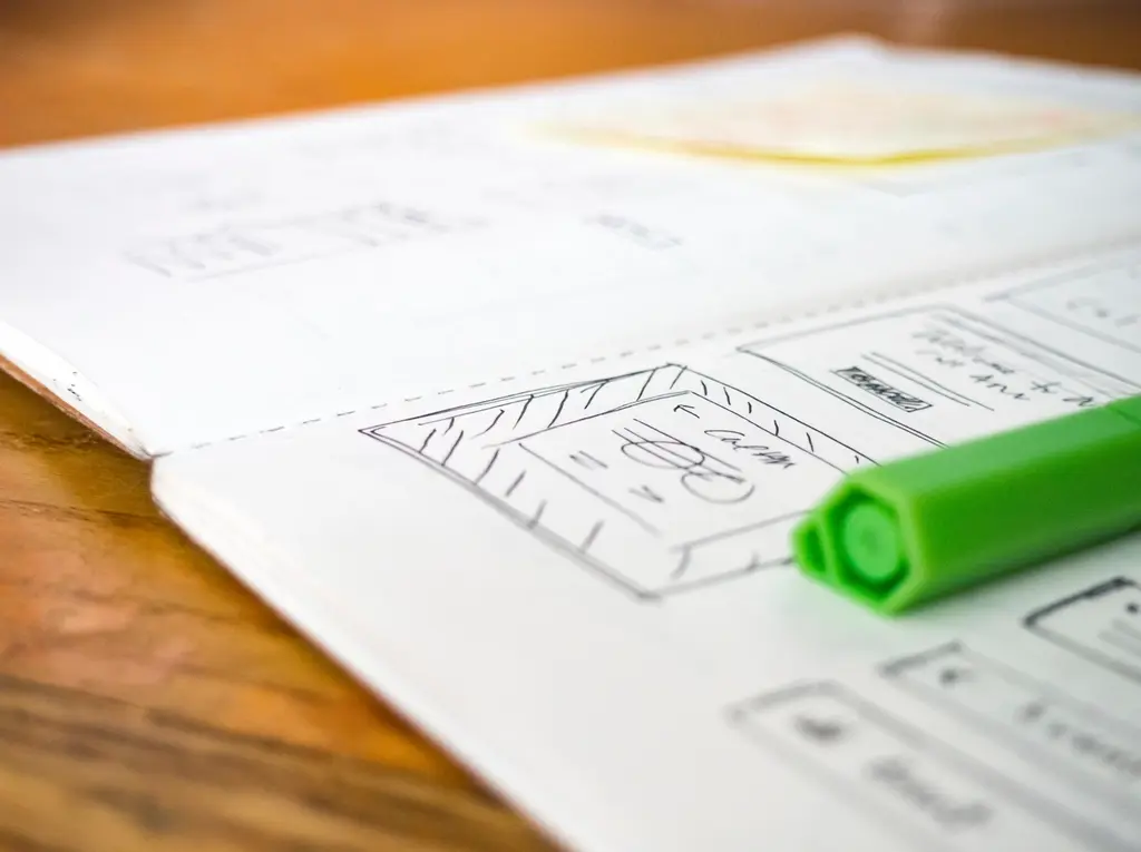 Open notebook showing a wireframe sketch with pen